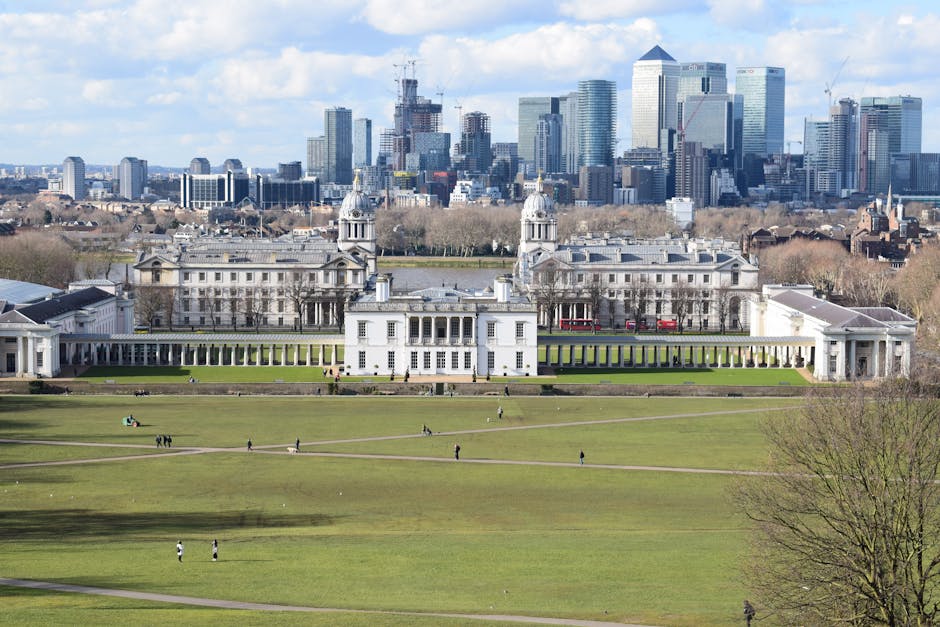 A historic domed building with classical architectural features, including columns and decorative stonework, situated in an urban environment with modern skyscrapers visible in the background. The clo